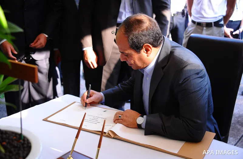 Egypt's President Abdel Fattah al-Sisi signs a guest book in front of "dendrobium Abdel Fattah al-Sisi" orchids named in his honour during a visit to the Botanical gardens in Singapore on August 31, 2015. President Abdel...