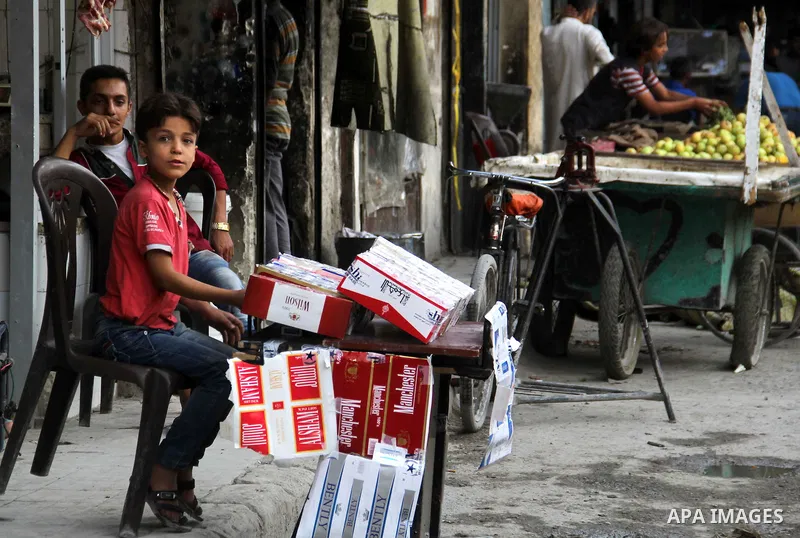 A Syrian boy sells cigarettes in a market in a rebel-controlled area in the northern Syrian city of Aleppo, on August 31, 2015. Photo by Ameer al-Halbi