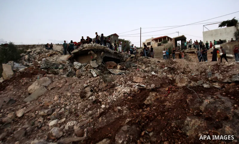 Palestinian men stand on the remains of house after Israeli bulldozers demolished during the Israeli operation, in the West Bank city of Jenin, on Sep. 01, 2015. Palestinian security officials said over 40 Israeli milita...