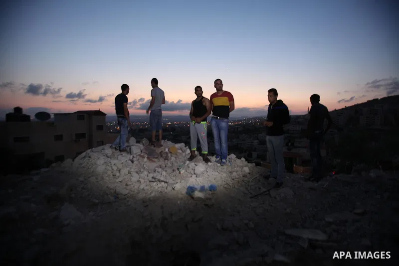 Palestinian men stand on the remains of house after Israeli bulldozers demolished during the Israeli operation, in the West Bank city of Jenin, on Sep. 01, 2015. Palestinian security officials said over 40 Israeli milita...