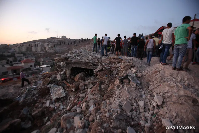 Palestinian men stand on the remains of house after Israeli bulldozers demolished during the Israeli operation, in the West Bank city of Jenin, on Sep. 01, 2015. Palestinian security officials said over 40 Israeli milita...