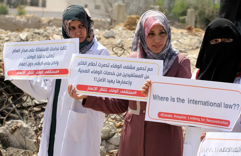 Palestinian Medical workers hold placards during a protest demanding reconstruction of El-Wafa hospital, which witnesses said was destroyed during a seven-week Israeli offensive, in the east of Gaza City on Sep. 01, 2015...