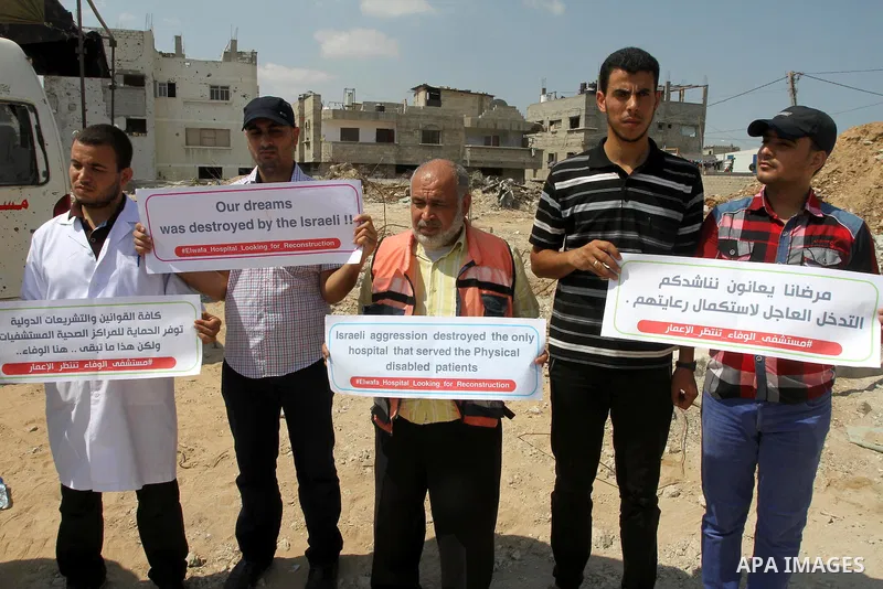 Palestinian Medical workers hold placards during a protest demanding reconstruction of El-Wafa hospital, which witnesses said was destroyed during a seven-week Israeli offensive, in the east of Gaza City on Sep. 01, 2015...