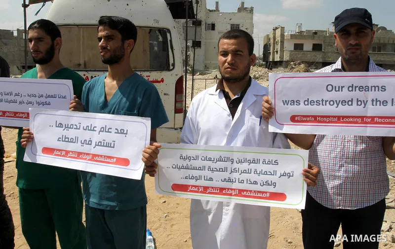 Palestinian Medical workers hold placards during a protest demanding reconstruction of El-Wafa hospital, which witnesses said was destroyed during a seven-week Israeli offensive, in the east of Gaza City on Sep. 01, 2015...
