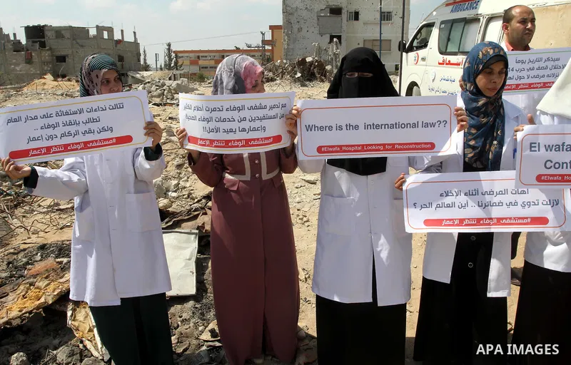 Palestinian Medical workers hold placards during a protest demanding reconstruction of El-Wafa hospital, which witnesses said was destroyed during a seven-week Israeli offensive, in the east of Gaza City on Sep. 01, 2015...