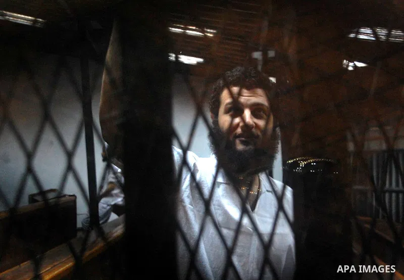 An Egyptian Muslim Brotherhood defendant sits behind the bars during his trial, along with ousted Islamist president Mohamed Morsi (unseen) in Cairo on Sep. 01, 2015. Cairo criminal court resumed proceedings in the 'Qata...