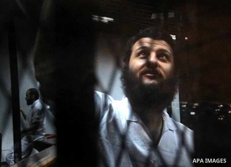 An Egyptian Muslim Brotherhood defendant sits behind the bars during his trial, along with ousted Islamist president Mohamed Morsi (unseen) in Cairo on Sep. 01, 2015. Cairo criminal court resumed proceedings in the 'Qata...