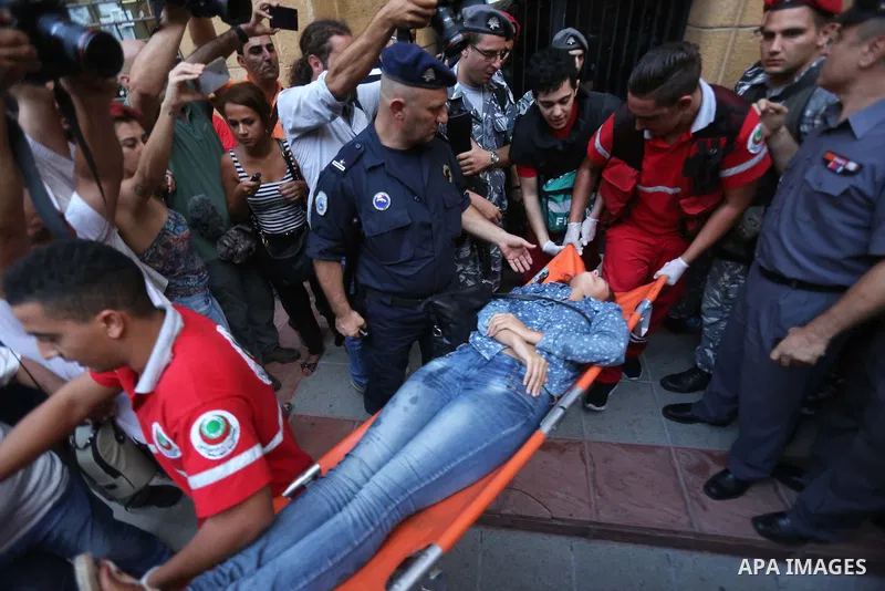 Lebanese activist Neemat Badr Eddine is carried unconscious on a stretcher by first aid medics as she is evacuated from the the environment ministry in downtown Beirut on September 1, 2015 after Lebanese police started f...