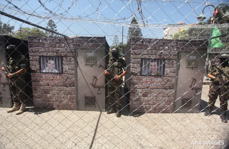 Palestinian militants of the Ezzedine al-Qassam Brigades, Hamas' armed wing, participate in the opening of the exhibition of the al-Qassam mock prisons, in Gaza city, on Sep. 02, 2015. Photo by Ashraf Amra