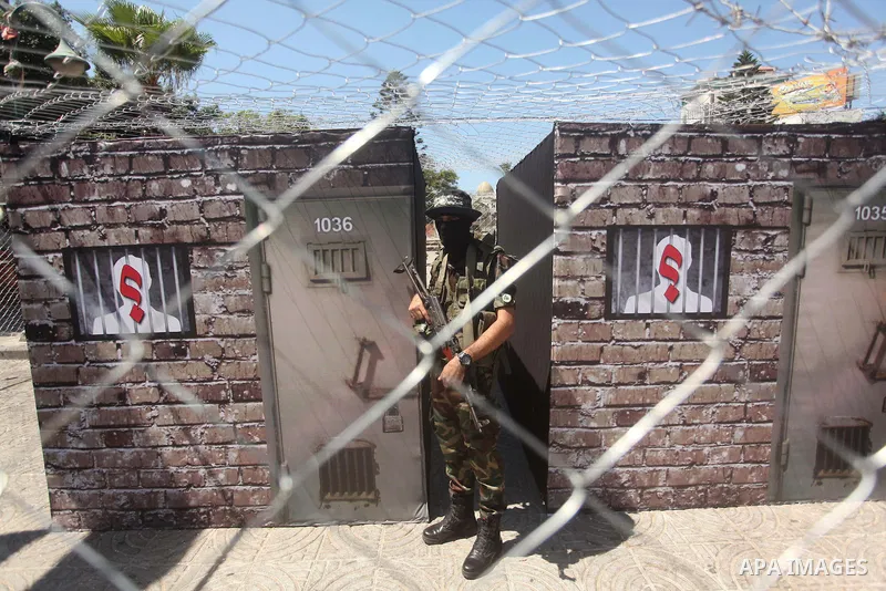 Palestinian militants of the Ezzedine al-Qassam Brigades, Hamas' armed wing, participate in the opening of the exhibition of the al-Qassam mock prisons, in Gaza city, on Sep. 02, 2015. Photo by Ashraf Amra