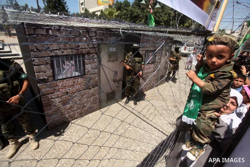 Palestinian militants of the Ezzedine al-Qassam Brigades, Hamas' armed wing, participate in the opening of the exhibition of the al-Qassam mock prisons, in Gaza city, on Sep. 02, 2015. Photo by Ashraf Amra