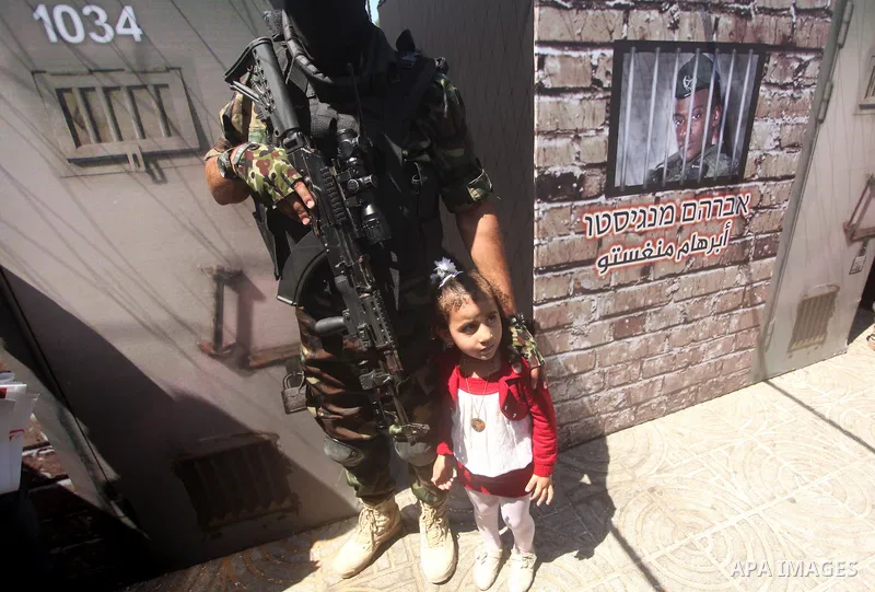 Palestinian militants of the Ezzedine al-Qassam Brigades, Hamas' armed wing, participate in the opening of the exhibition of the al-Qassam mock prisons, in Gaza city, on Sep. 02, 2015. Photo by Ashraf Amra