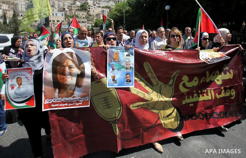 Palestinian protesters hold posters during a protest to show soldarity with prisoners, in the West Bank city of Nablus, on Sep. 03, 2015. Photo by Nedal Eshtayah