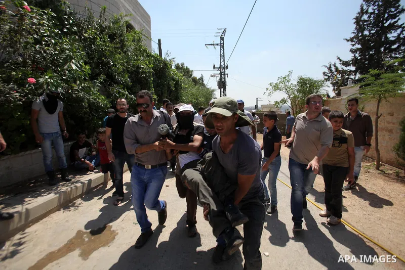 A Palestinian man is carried away by fellow protesters after he was injured during clashes with Israeli security forces following a demonstration against the expropriation of Palestinian land by Israel, in the village of...