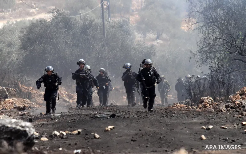 Israeli security forces run after Palestinian protesters during clashes following a demonstration against the expropriation of Palestinian land by Israel, in the village of Kfar Qaddum, near Nablus in the occupied West B...