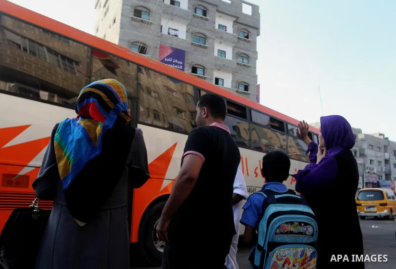 Palestinians wave as they sit in a bus before leaving the Rafah border crossing for the annual haj pilgrimage in Mecca, in the southern Gaza Strip September 7, 2015. Hundreds of Palestinian pilgrims are leaving Gaza thro...