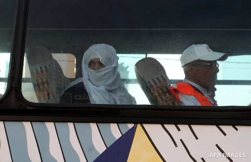 Palestinians wave as they sit in a bus before leaving the Rafah border crossing for the annual haj pilgrimage in Mecca, in the southern Gaza Strip September 7, 2015. Hundreds of Palestinian pilgrims are leaving Gaza thro...