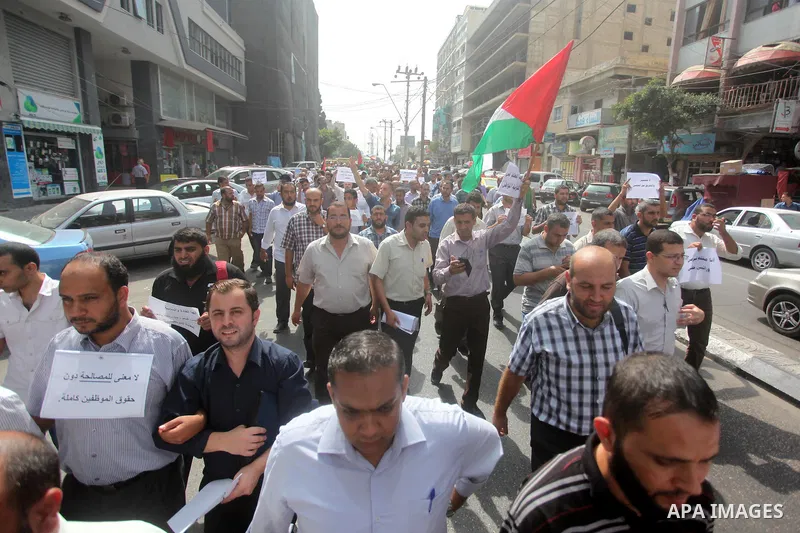 Palestinian teachers hold banners during a protest to demand their salaries and their rights, in Gaza City, on September 7, 2015. Photo by Ashraf Amra