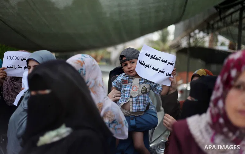 Palestinian teachers hold banners during a protest to demand their salaries and their rights, in Gaza City, on September 7, 2015. Photo by Ashraf Amra