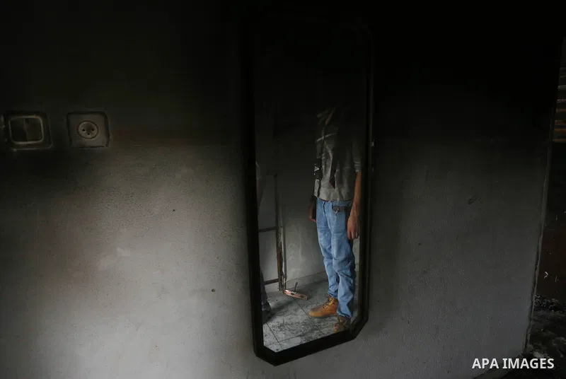 A Palestinian man inspects the house of Dawabsha family in the village of Duma, near the occupied West Bank city of Nablus on September 7, 2015. Riham Dawabsha, the mother of a Palestinian child killed in the July firebo...