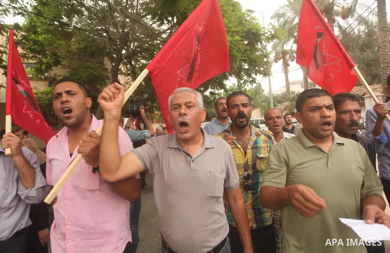 Palestinian supporters of the Democratic Front for the Liberation of Palestine (DFLP) chant slogans during a demonstration in support of the Dawabsha family, whose house was fired bomb by Jewish extremists in the Israeli...