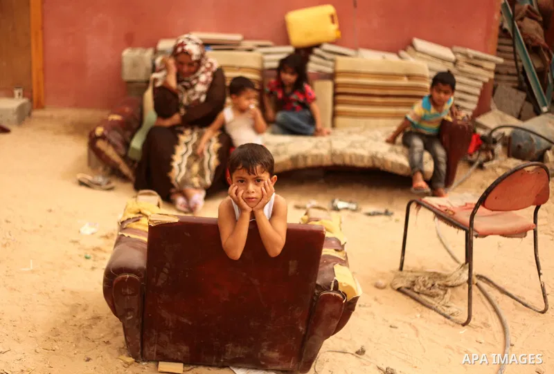 Palestinians sit outside their house that witnesses said were destroyed by Israeli during a 50-day shelling in 2014 summer, during a sandstorm in Khan Younis in the southern Gaza Strip, September 9, 2015. A heavy sandsto...