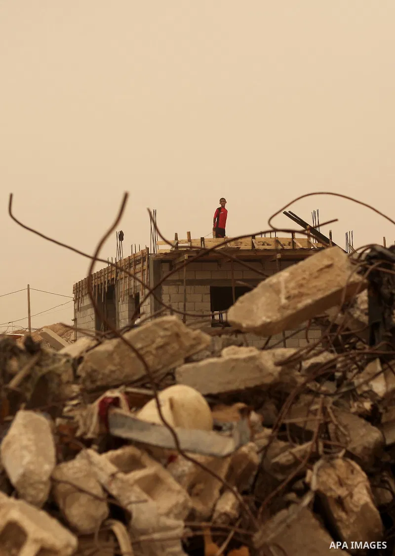 A Palestinian man stands on the rubble of a house that witnesses said were destroyed by Israeli during a 50-day shelling in 2014 summer, during a sandstorm in Khan Younis in the southern Gaza Strip, September 9, 2015. A...