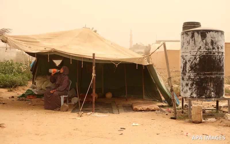 A Palestinian woman sits outside her shelter during a sandstorm in Khan Younis in the southern Gaza Strip, September 9, 2015. A heavy sandstorm swept across parts of the Middle East on Tuesday, killing two people and hos...