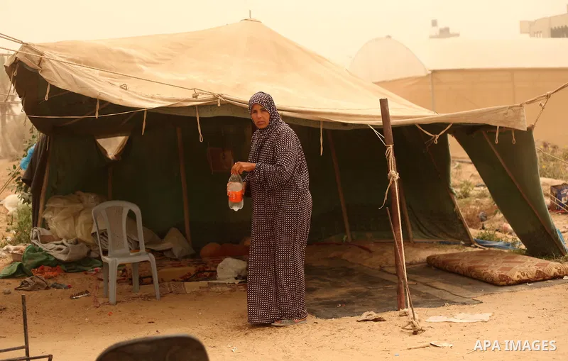 A Palestinian woman stands outside her shelter during a sandstorm in Khan Younis in the southern Gaza Strip, September 9, 2015. A heavy sandstorm swept across parts of the Middle East on Tuesday, killing two people and h...