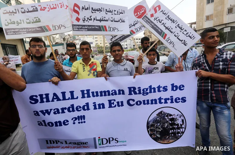 Palestinians take part in a protest demanding reconstruction of houses which were destroyed during the recent Israeli war, in front of the headquarters of the United Nations Relief and Works Agency (UNRWA), in Gaza city,...