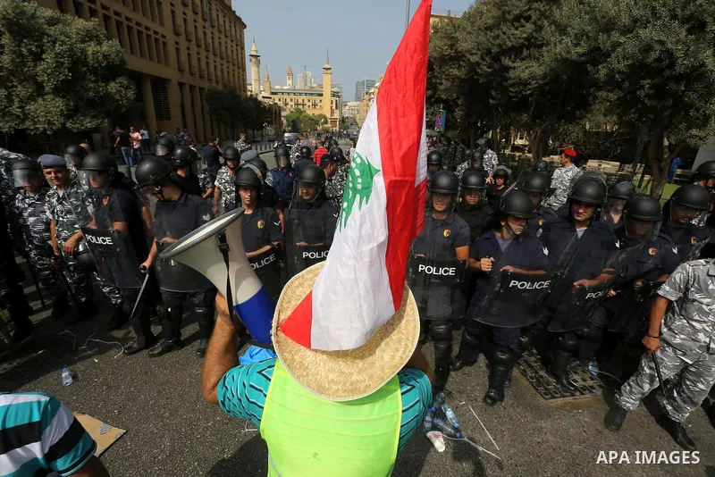 A Lebanese activist from 'You Stink' campaign shouts slogans in front of riot police during a protest against today s session of a dialogue of top political figures, accused by the group of failing to resolve a crisis ov...