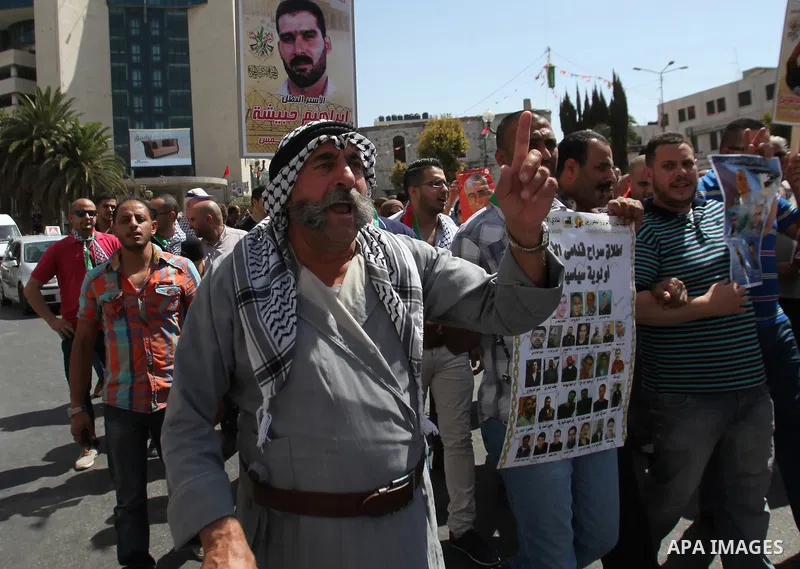 Palestinian protesters hold posters during a protest to show solidarity with Palestinian prisoners in Israeli jails, in the West Bank city of Nablus, on Sep. 17, 2015. Photo by Nedal Eshtayah