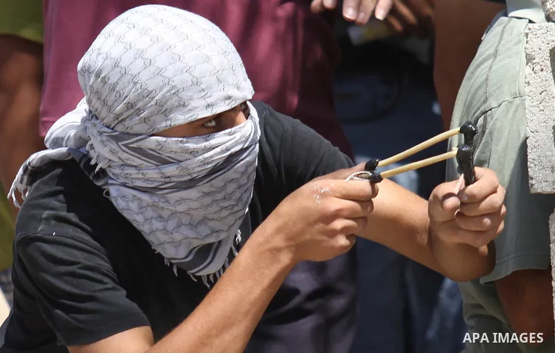 A Palestinian protester uses a sling shot to hurl a stone towards Israeli security forces during clashes following a demonstration in defence of the Al-Aqsa mosque, Islam s third holiest site, located in Jerusalem's old...