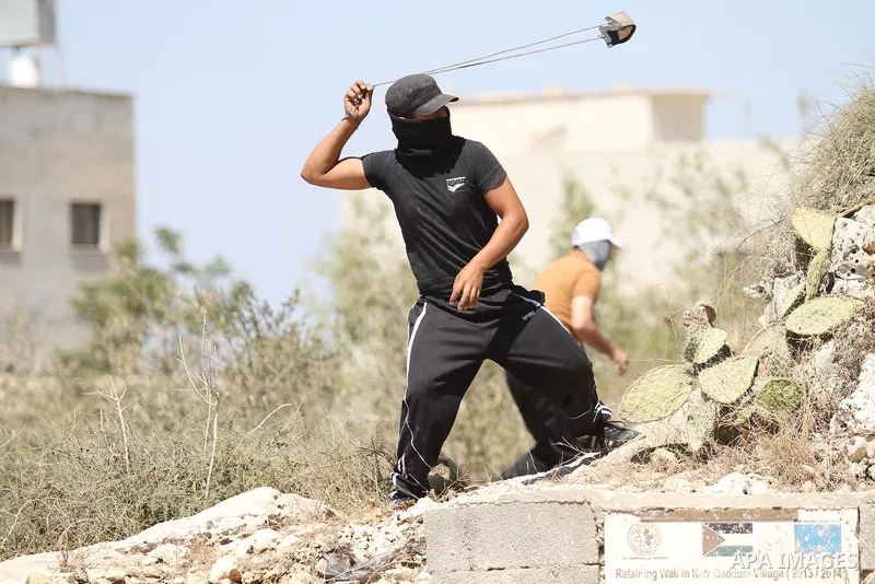 A Palestinian protester uses a sling shot to hurl a stone towards Israeli security forces during clashes following a demonstration in defence of the Al-Aqsa mosque, Islam s third holiest site, located in Jerusalem's old...