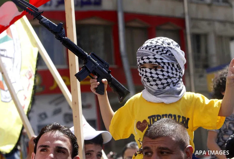 A Masked Palestinian boy holds a toy gun during a demonstration in defence of the Al-Aqsa mosque, Islam s third holiest site, located in Jerusalem's old city, after the weekly Friday prayers, in the occupied West Bank ci...