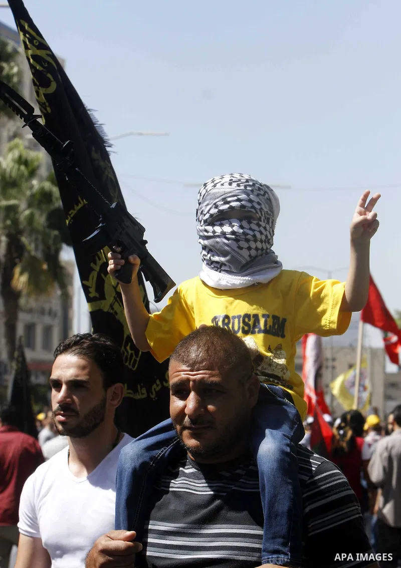 A Masked Palestinian boy holds a toy gun during a demonstration in defence of the Al-Aqsa mosque, Islam s third holiest site, located in Jerusalem's old city, after the weekly Friday prayers, in the occupied West Bank ci...