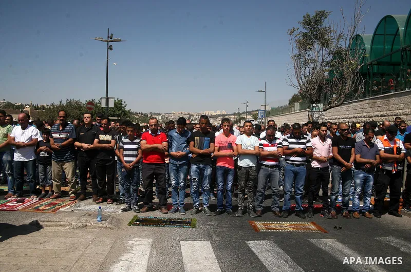 Palestinian Muslim worshippers, under the age of 40 years old, perform the traditional Friday prayers on a street as Israeli police blocks the access to Al-Aqsa Mosque, outside the Old City walls in East Jerusalem on Sep...