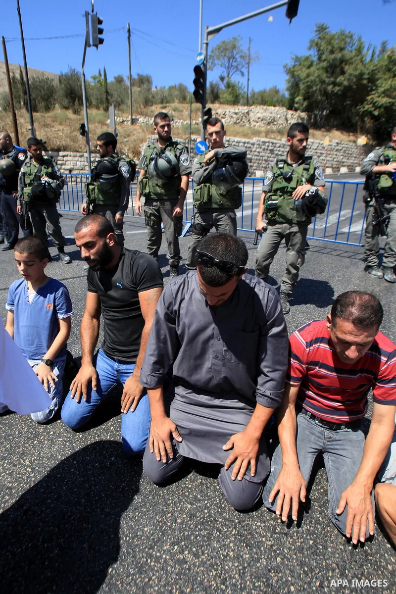 Palestinian Muslim worshippers, under the age of 40 years old, perform the traditional Friday prayers on a street as Israeli police blocks the access to Al-Aqsa Mosque, outside the Old City walls in East Jerusalem on Sep...