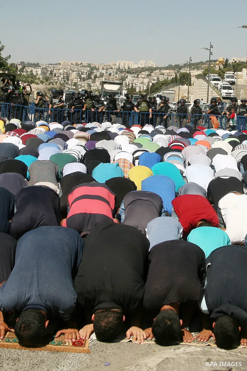 Palestinian Muslim worshippers, under the age of 40 years old, perform the traditional Friday prayers on a street as Israeli police blocks the access to Al-Aqsa Mosque, outside the Old City walls in East Jerusalem on Sep...