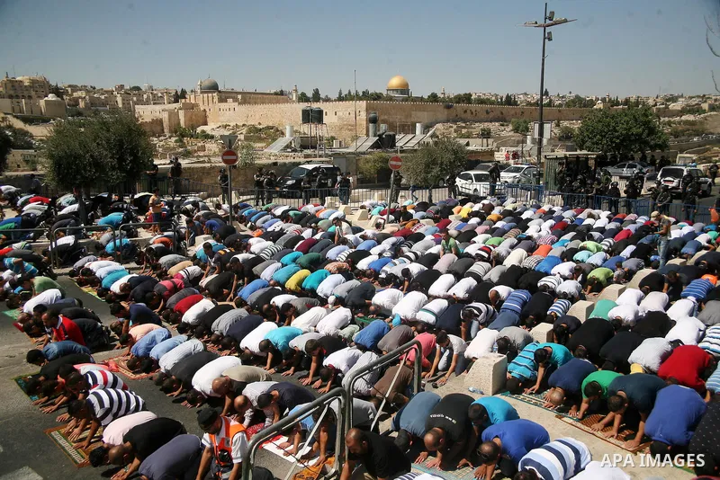 Palestinian Muslim worshippers, under the age of 40 years old, perform the traditional Friday prayers on a street as Israeli police blocks the access to Al-Aqsa Mosque, outside the Old City walls in East Jerusalem on Sep...