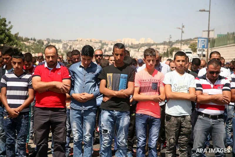 Palestinian Muslim worshippers, under the age of 40 years old, perform the traditional Friday prayers on a street as Israeli police blocks the access to Al-Aqsa Mosque, outside the Old City walls in East Jerusalem on Sep...