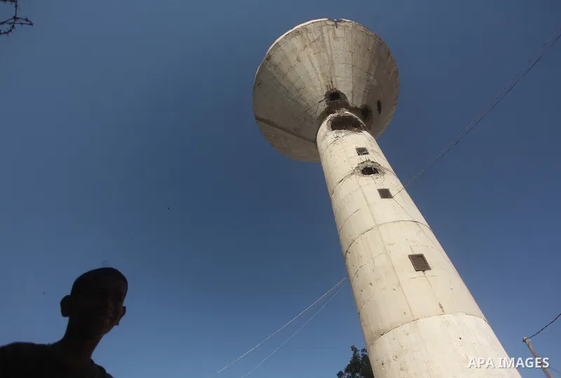 Palestinian boys look at a water tower targeted by an Israeli air strike overnight in the northern Gaza strip of Beit Hanun on September 19, 2015. Two rockets were fired into southern Israel by Palestinian militants in G...