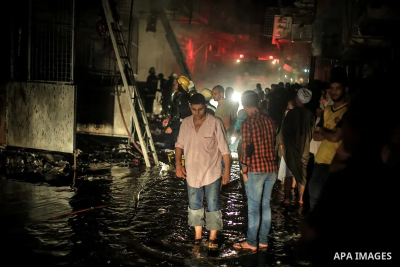 Egyptian firefighters inspect the damage following a fire broke out in al-Gamaliya district, in Cairo on September 20, 2015. At least 4 persons were injured as a number of stores and shops caught fire today, morning, in...