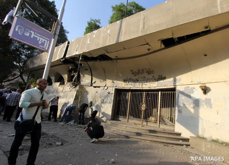 Egyptian security forces and passersby look at the damage after a small bomb went off near administrative offices of the foreign ministry in the capital Cairo on September 20, 2015. Photo by Amr Sayed
