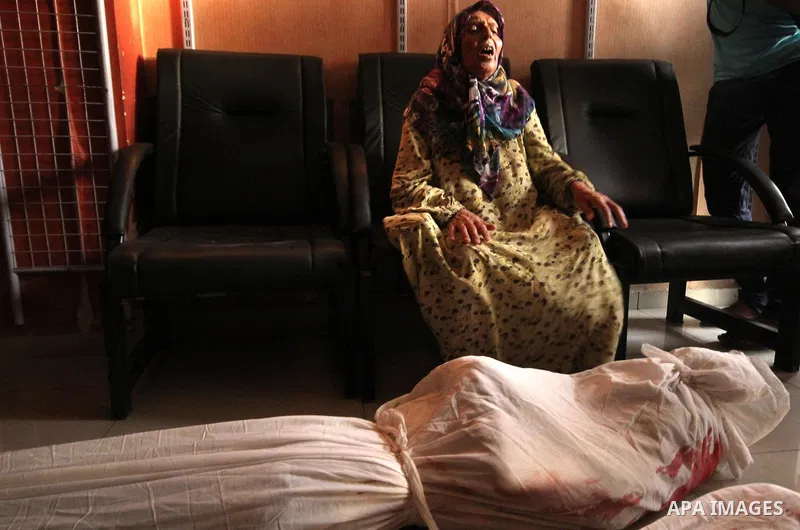 A Syrian woman mourns over the body of a relative following an air strike by government forces on the al-Mowasalat neighbourhood of the northern Syrian city of Aleppo on September 20, 2015. Photo by Ameer al-Halbi