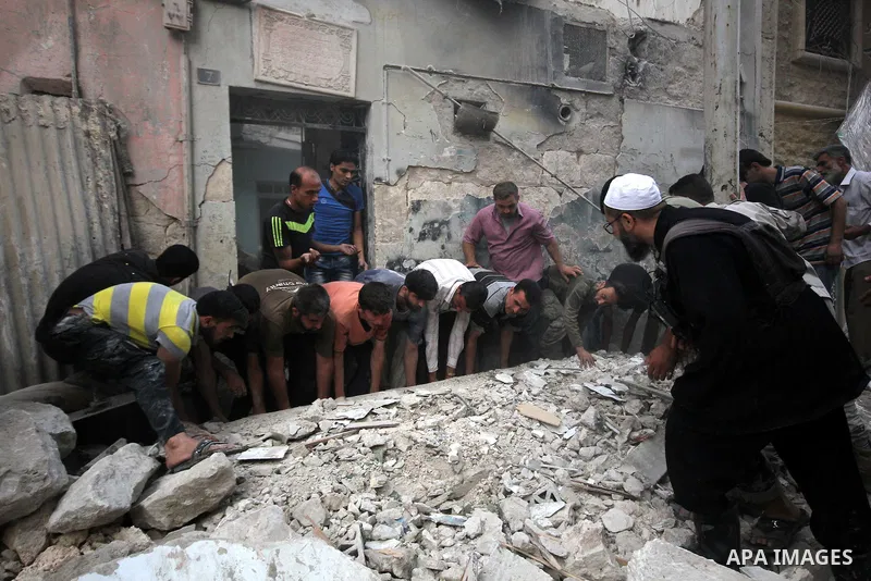 Syrians remove the debris following an air strike by government forces on the al-Mowasalat neighbourhood of the northern Syrian city of Aleppo on September 20, 2015. Photo by Ameer al-Halbi