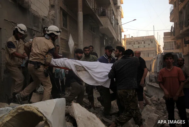 Mourners carry the body of a Syrian man following an air strike by government forces on the al-Mowasalat neighbourhood of the northern Syrian city of Aleppo on September 20, 2015. Photo by Ameer al-Halbi