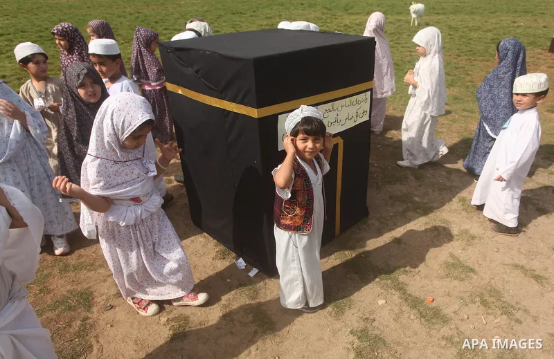 Palestinian children gather around a makeshift cube representing the holy Kaaba in Gaza city, on Sept. 21, 2015, as part of training children how to perform Hajj pilgrimage. Muslims from around the world flood Saudi city...