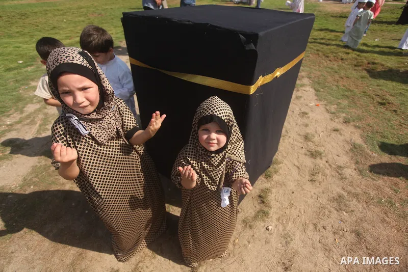 Palestinian children gather around a makeshift cube representing the holy Kaaba in Gaza city, on Sept. 21, 2015, as part of training children how to perform Hajj pilgrimage. Muslims from around the world flood Saudi city...