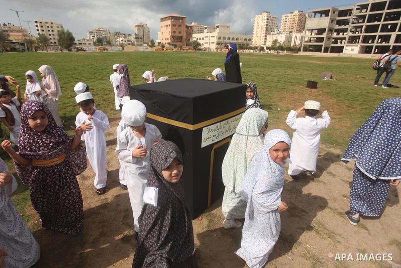 Palestinian children gather around a makeshift cube representing the holy Kaaba in Gaza city, on Sept. 21, 2015, as part of training children how to perform Hajj pilgrimage. Muslims from around the world flood Saudi city...